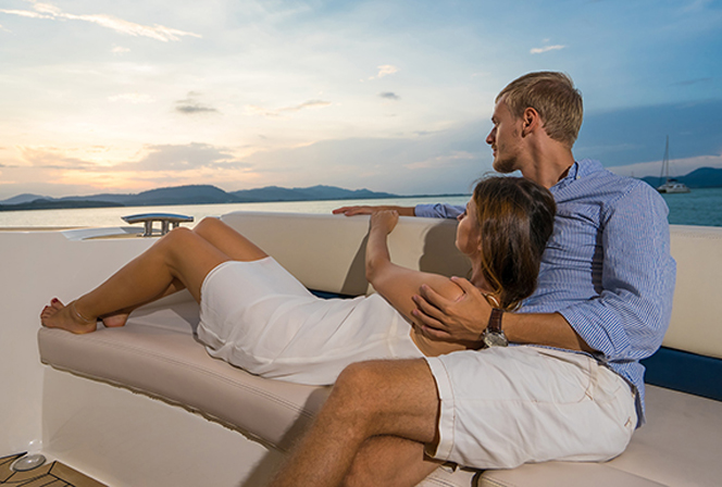 rich couple watching sunset from boat